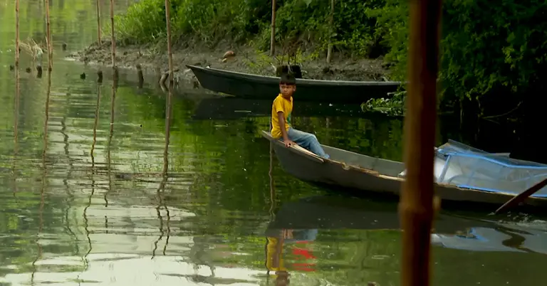 নৌকায় বসে আছে একটি ছেলে
