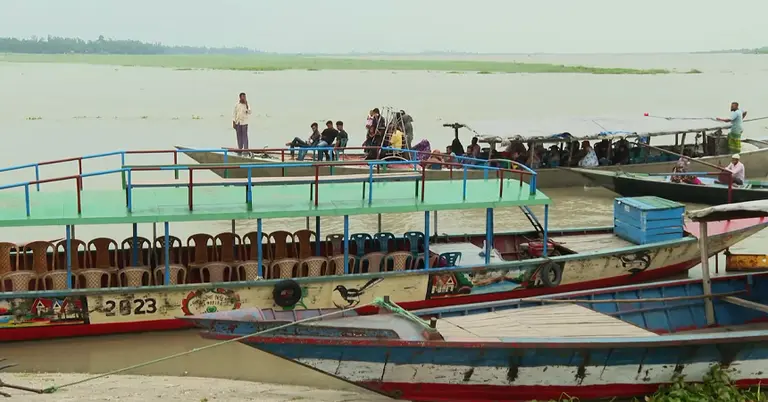 নৌকায় করে ঘাট পার হচ্ছেন যাত্রীরা